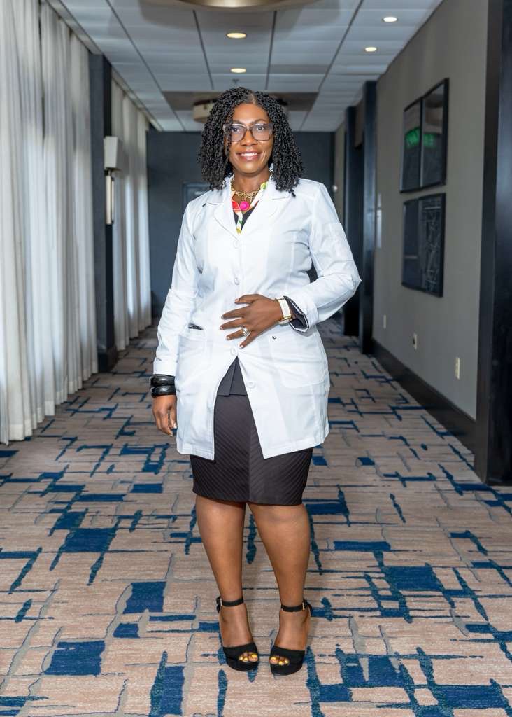 Dr. Juliana Atem, DNP, standing in a white coat